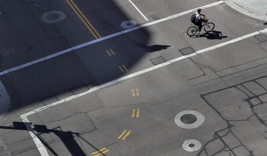 A lone cyclist crosses an empty street in downtown Phoenix Wednesday, April 1, 2020 during the first full day of Arizona Gov. Doug Ducey&#x27;s stay-at-home order to slow the spread of the new coronavirus. Gov. Ducey is urging Arizonans to be understanding and reasonable as people and businesses face April 1 due dates for bills such as mortgages, rent, utilities and internet service since the COVID-19 coronavirus outbreak has slowed the economy. The new coronavirus causes mild or moderate symptoms for most people, but for some, especially older adults and people with existing health problems, it can cause more severe illness or death. (AP Photo/Matt York)