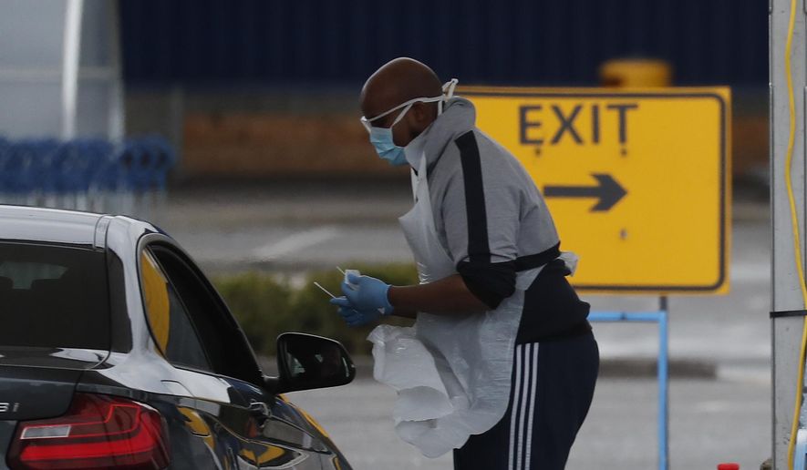 National Health Service staff wait in their cars to take a coronavirus test at a drive through centre in north London, Wednesday, April 1, 2020. The new coronavirus causes mild or moderate symptoms for most people, but for some, especially older adults and people with existing health problems, it can cause more severe illness or death.(AP Photo/Frank Augstein)