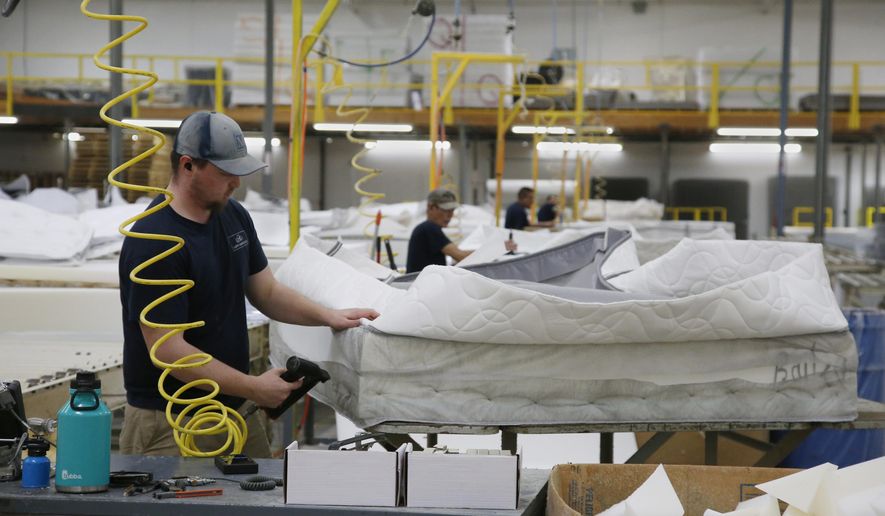 Workers at the Mathis Brothers mattress factory continue construction mattress as part of the factory has been given over to sewing mask for hospital use, Wednesday, April 1, 2020, in Oklahoma City. The new coronavirus causes mild or moderate symptoms for most people, but for some, especially older adults and people with existing health problems, it can cause more severe illness or death. (AP Photo/Sue Ogrocki)