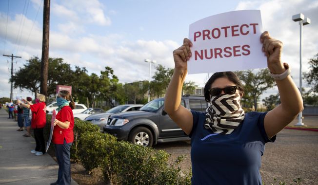 Nurses at Corpus Christi Medical Center - Doctor&#x27;s Regional protests the lack of personal protective equipment and COVID-19 preparedness at the hospital in Corpus Christi, Texas on Wednesday, April 1, 2020. (Courtney Sacco/Corpus Christi Caller-Times via AP)