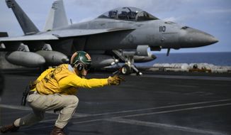 PACIFIC OCEAN (May 2, 2018) Lt. Adam Hall signals for an F/A-18F Super Hornet assigned to the Fighting Redcocks of Strike Fighter Attack Squadron (VFA) 22 to launch on the flight deck of the aircraft carrier USS Theodore Roosevelt (CVN 71). (U.S. Navy photo)