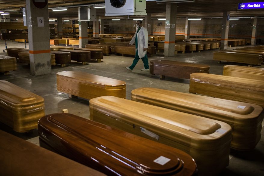 In this file photo, coffins with the bodies of victims of coronavirus are stored waiting for burial or cremation at the Collserola morgue in Barcelona, Spain, Thursday, April 2, 2020. (AP Photo/Emilio Morenatti) **FILE**