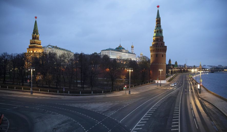 A view of the unusually empty embankment during evening rush hour outside the Kremlin in Moscow, Russia, Wednesday, April 1, 2020. The Kremlin is pushing back against accusations that the coronavirus was created in a Chinese lab, calling it "unacceptable" to make such an accusation. (AP Photo/Pavel Golovkin)