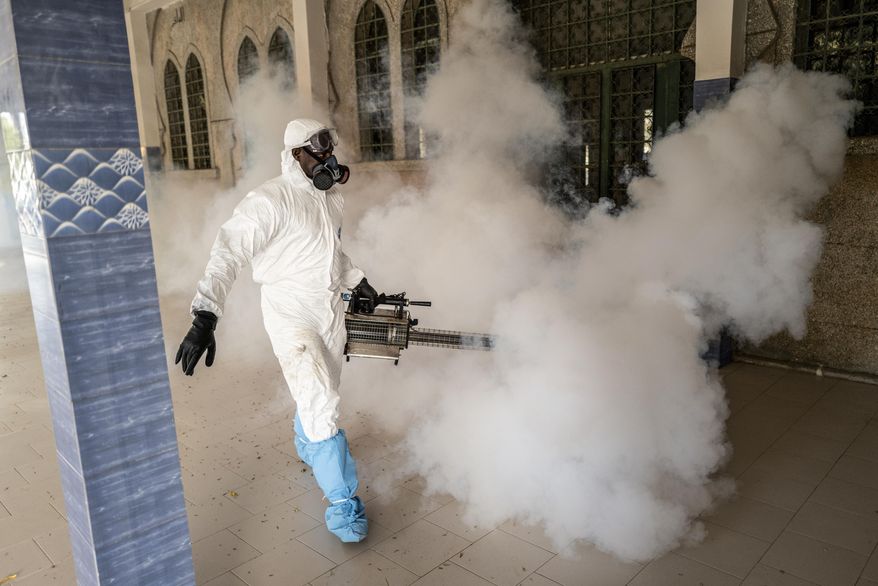 In this Wednesday, April 1, 2020, photo, a municipal worker sprays disinfectant in a mosque to help curb the spread of the new coronavirus in Dakar, Senegal. The new coronavirus causes mild or moderate symptoms for most people, but for some, especially older adults and people with existing health problems, it can cause more severe illness or death. (AP Photo/Sylvain Cherkaoui)
