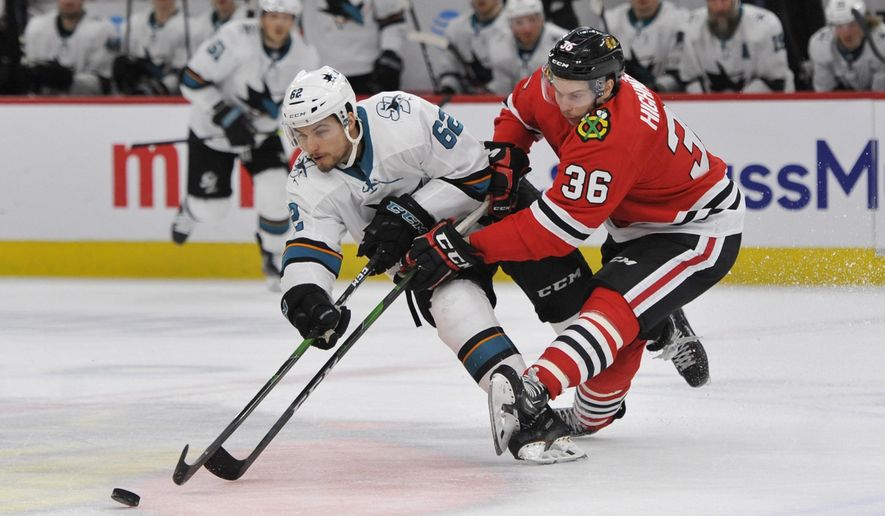 Chicago Blackhawks' Matthew Highmore (36) battles San Jose Sharks' Kevin Labanc (62) for a loose puck during the third period of an NHL hockey game Wednesday, March 11, 2020, in Chicago. Chicago won 6-2. (AP Photo/Paul Beaty)