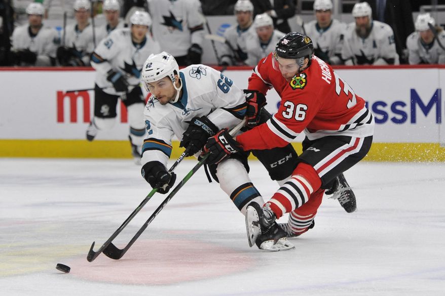 Chicago Blackhawks' Matthew Highmore (36) battles San Jose Sharks' Kevin Labanc (62) for a loose puck during the third period of an NHL hockey game Wednesday, March 11, 2020, in Chicago. Chicago won 6-2. (AP Photo/Paul Beaty)