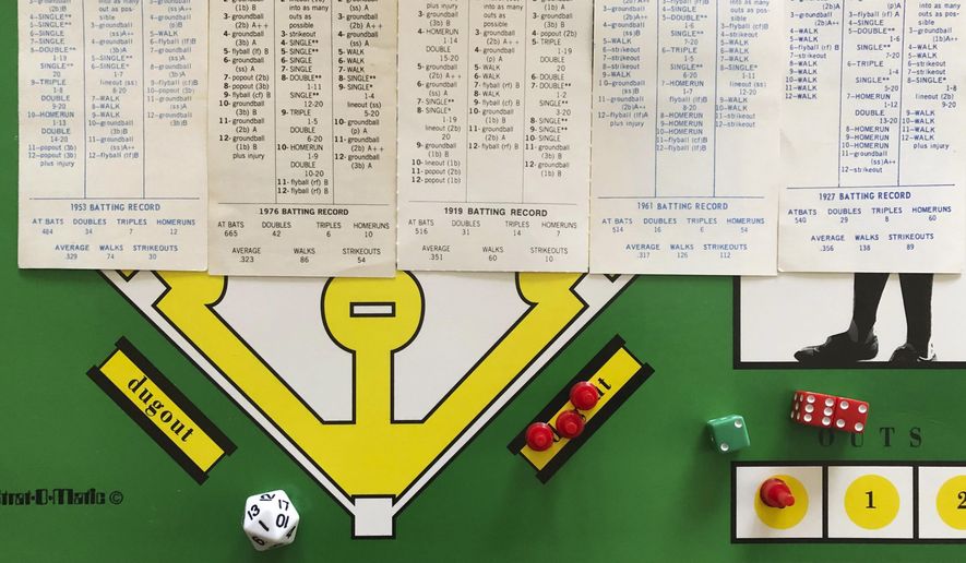 In this April 1, 2020, photo, AP correspondent Dan Sewell in Cincinnati plays in a tournament at home using the Strat-O-Matic baseball board game while self-isolating due to the coronavirus outbreak. With no real baseball being played, fans are getting their fixes with conference call chats, trivia contests and fantasy games. (AP Photo/Dan Sewell)