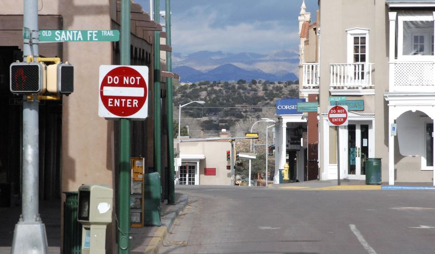 An empty street and closed stores are shown at a central plaza and shopping district amid a public health order that has closed down most retail stores and suspended dine-in restaurant service in Santa Fe, N.M., Friday, March 27, 2020. New Mexico Cabinet Secretary for Tourism Jen Schroer says the state&#39;s tourism industry will continue to suffer amid COVID-19 restrictions and vowed the state will do what it can to help hotels, tourist spots, and businesses recover once restrictions are lifted. (AP Photo/Morgan Lee)