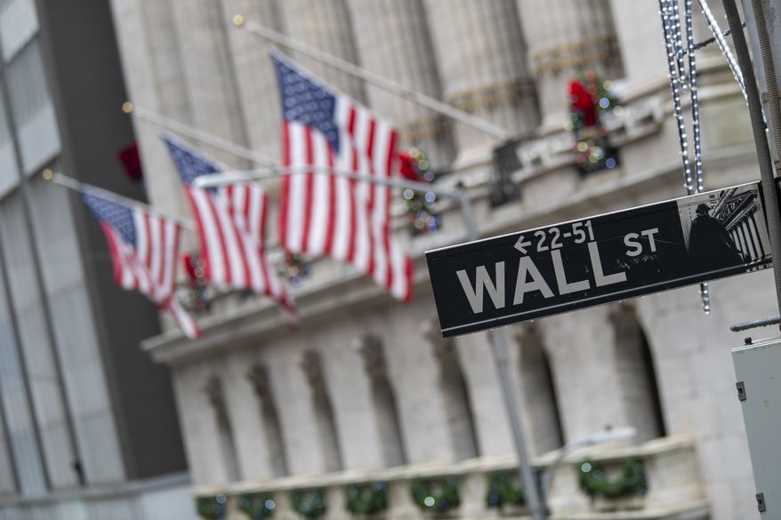 In this Jan. 3, 2020, file photo, the Wall St. street sign is framed by U.S. flags flying outside the New York Stock Exchange in New York. (AP Photo/Mary Altaffer, File)