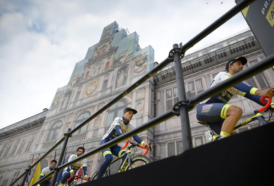 FILE - In this Sunday, April 7, 2019 file photo, Belgium's Ludwig De Winter of the Wanty-Gobert team, right, leads the rest of his team up to the podium during the team presentations for the Tour of Flanders cycling race in Antwerp, Belgium. One of the five so-called “Monuments” _ the five most prestigious one-day races in cycling _ the “Ronde" has been scrapped from this season's calendar because of the outbreak of the coronavirus. All schools in the country have been shut down, only a handful of businesses remain open for essential needs while riding bikes in large groups has been forbidden. To keep the festive event alive, race organizers Flanders Classics will host a “lockdown edition" of the race on Sunday, April 5, 2020 with pro riders tackling the punishing Oude Kwaremont and Paterberg climbs from the comfort of their houses, on home trainers. (AP Photo/Virginia Mayo, File)