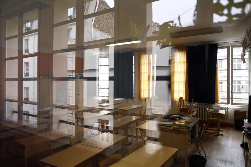 An empty classroom is seen at a closed school in Paris, Monday, March 16, 2020. France plans to close all creches, schools and universities from Monday until further notice to limit the spread of the novel coronavirus, President Emmanuel Macron says. For most people, the new coronavirus causes only mild or moderate symptoms. For some it can cause more severe illness, especially in older adults and people with existing health problems. (AP Photo/Thibault Camus)