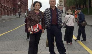 This May 13, 2019 photo provided by Liu Dong’e shows her and her husband, Wu Chuanyong, while visiting Moscow. Wu Chuanyong had been enjoying a peaceful retirement in the central Chinese city of Wuhan. The 68-year-old family patriarch began each morning with a stroll through the park and ended the day watching television dramas. Then the coronavirus hit, quickly spreading in Wuhan and around the world. (Courtesy Liu Dong’e via AP)