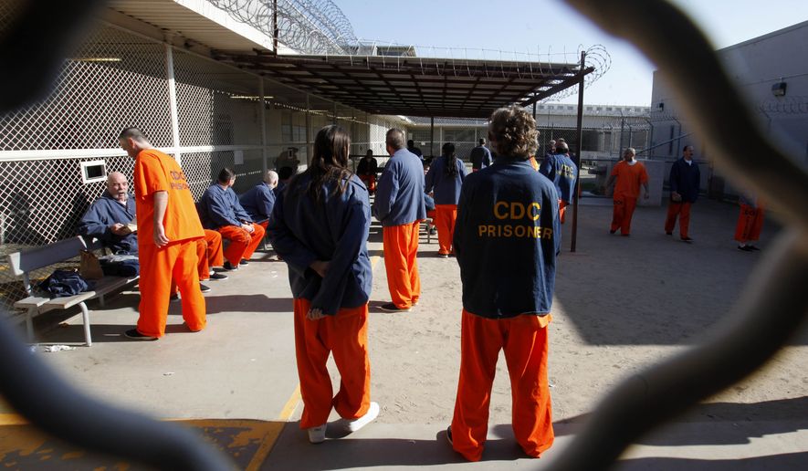 In this Jan. 12, 2012, file photo, inmates walk around a recreation yard at the Deuel Vocational Institution in Tracy, Calif. A three-judge federal panel refused on procedural grounds Saturday, April 4, 2020, to order California to free thousands of prisoners to ease crowded conditions that attorneys representing inmates say could ignite a rapid spread of the coronavirus. (AP Photo/Rich Pedroncelli, File)