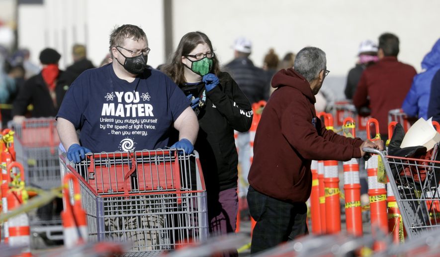People wear masks as they wait in line at Costco Saturday, April 4, 2020, in Salt Lake City. The Centers for Disease Control and Prevention is now advising Americans to voluntarily wear a basic cloth or fabric face mask to help curb the spread of the new coronavirus. (AP Photo/Rick Bowmer)