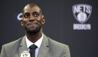FILE - In this July 18, 2013 file photo, Kevin Garnett smiles as he speaks to reporters during an NBA basketball news conference in New York.  Garnett and fellow NBA greats Tim Duncan and Kobe Bryant headlined a nine-person group announced Saturday, April 4, 2020,  as this year’s class of enshrinees into the Naismith Memorial Basketball Hall of Fame. They all got into the Hall in their first year of eligibility, as did WNBA great Tamika Catchings. Two-time NBA champion coach Rudy Tomjanovich, longtime Baylor women’s coach Kim Mulkey, 1,000-game winner Barbara Stevens of Bentley and three-time Final Four coach Eddie Sutton were selected. So was former FIBA Secretary General Patrick Baumann. (AP Photo/Mary Altaffer, File)