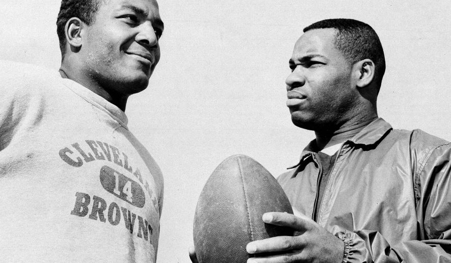 FILE - In this Jan. 11, 1964, file photo, fullback Jim Brown, left, and flanker back Bobby Mitchell, once a feared duo for the Cleveland Browns before Mitchell was dealt to Washington, are back together as teammates, as they prepare for the annual Pro Bowl at Los Angeles. Mitchell, the speedy late 1950s and ’60s NFL offensive star the Browns and the Washington Redskins, has died. He was 84. The Pro Football Hall of Fame said Sunday night, April 5, 2020, that Mitchell’s family said he died in the afternoon. (AP Photo/Harold Filan, File)