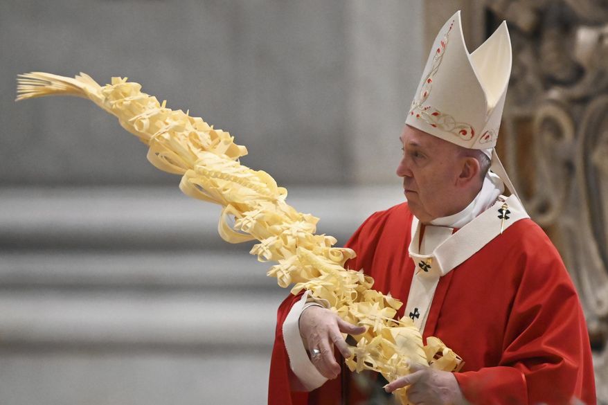 Pope Francis holds a palm branch as he celebrates Palm Sunday Mass behind closed doors in St. Peter's Basilica, at the Vatican, Sunday, April 5, 2020, during the lockdown aimed at curbing the spread of the COVID-19 infection, caused by the novel coronavirus. (AP Photo/pool/Alberto Pizzoli)