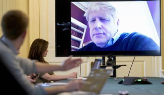 FILE - In this Saturday, March 28, 2020 handout photo provided by Number 10 Downing Street, Britain&#39;s Prime Minister Boris Johnson chairs the morning Covid-19 Meeting remotely after self isolating after testing positive for the coronavirus, at 10 Downing Street, London. British Prime Minister Boris Johnson has been admitted to a hospital with the coronavirus. Johnson’s office says he is being admitted for tests because he still has symptoms 10 days after testing positive for the virus. (Andrew Parsons/10 Downing Street via AP, File)