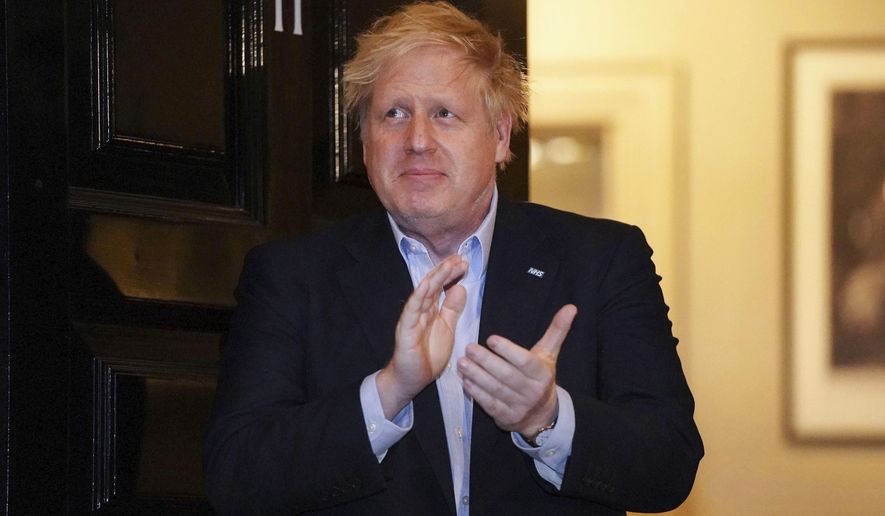 FILE - In this Thursday, April 2, 2020 handout photo provided by 10 Downing Street, Britain's Prime Minister Boris Johnson claps outside 11 Downing Street to salute local heroes during Thursday's nationwide Clap for Carers NHS initiative to applaud workers fighting the coronavirus pandemic, in London. British Prime Minister Boris Johnson has been admitted to a hospital with the coronavirus. Johnson’s office says he is being admitted for tests because he still has symptoms 10 days after testing positive for the virus. (Pippa Fowles/10 Downing Street via AP, File)
