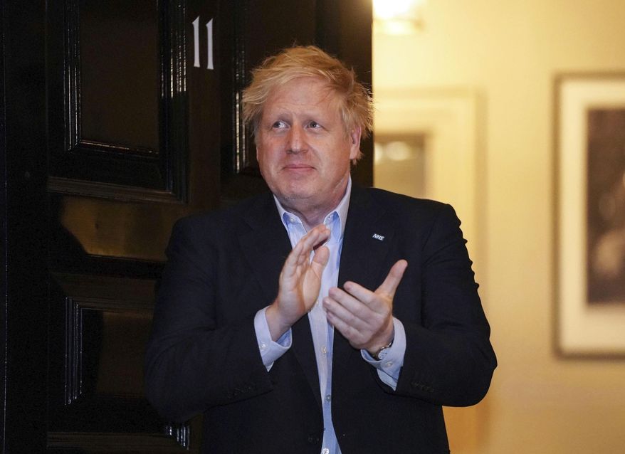FILE - In this Thursday, April 2, 2020 handout photo provided by 10 Downing Street, Britain's Prime Minister Boris Johnson claps outside 11 Downing Street to salute local heroes during Thursday's nationwide Clap for Carers NHS initiative to applaud workers fighting the coronavirus pandemic, in London. British Prime Minister Boris Johnson has been admitted to a hospital with the coronavirus. Johnson’s office says he is being admitted for tests because he still has symptoms 10 days after testing positive for the virus. (Pippa Fowles/10 Downing Street via AP, File)