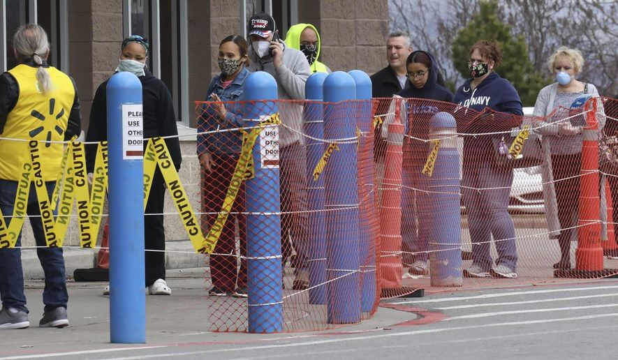 A line of shoppers wait for their chance to get into the Wilkes Barre Twp, Pa., Walmart, Saturday, April 4, 2020, as the business begins limiting the amount of customers allowed into the store as a result of the coronavirus outbreak. (Dave Scherbenco/The Citizens&#x27; Voice via AP)