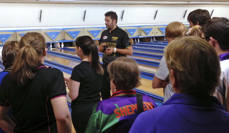 In this April 20, 2013 photo, Australian pro bowler Jason Belmonte, center, gives instructions during a clinic on the Sunshine Coast, Australia. Belmonte's return to Australia from another banner season on the PBA Tour in the United States was never going to be easy due to a logjam of Australians trying to return Down Under because of the coronavirus shutdown. (AP Photo/Dennis Passa)