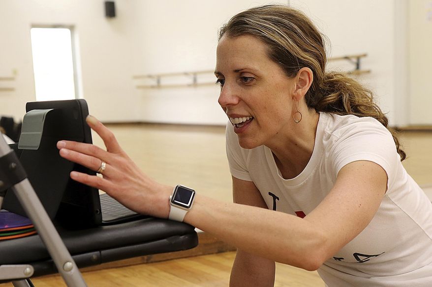 Christy Remington, owner of Prima School of Dancing in Rapid City, S.D., encourages students in her first-grade class during their online class Monday, March 30, 2020. (Jeff Easton/Rapid City Journal via AP)