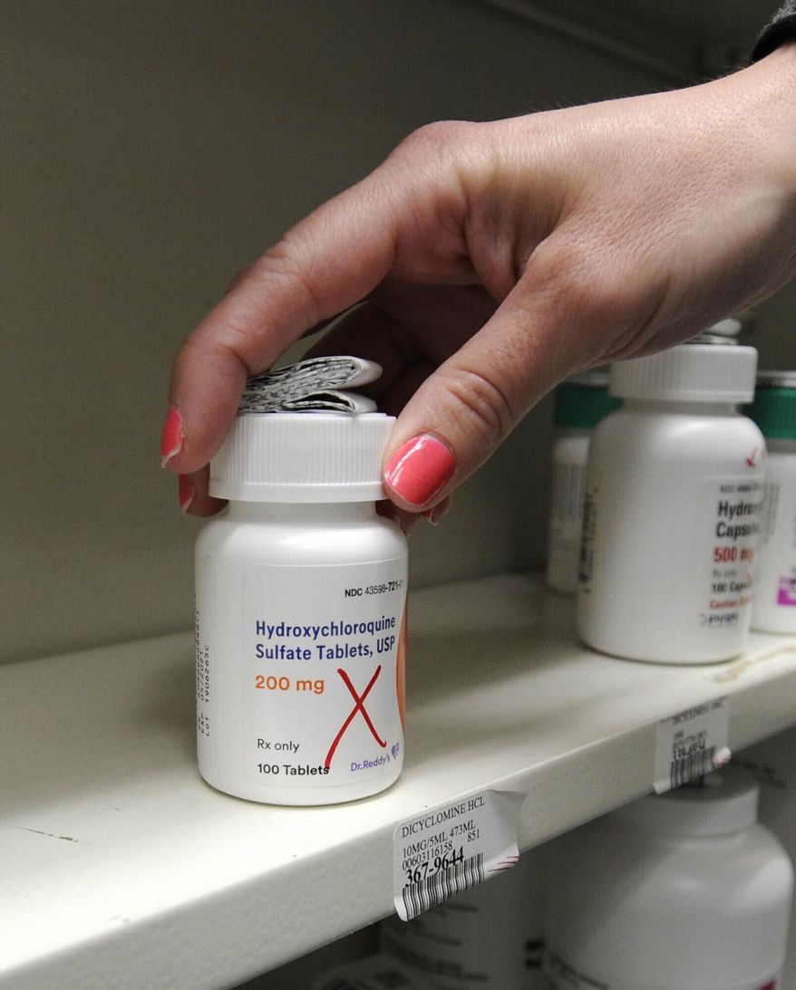 In this March 31, 2020 file photo pharmacist Amanda Frank reaches for a bottle of Hydroxychloroquine at the Medicine Shoppe in Wilkes-Barre, Pa. Some politicians and doctors are sparring over whether to use hydroxychloroquine against the new coronavirus, with many of scientists saying the evidence is too thin to recommend it now. (Mark Moran/The Citizens' Voice via AP, file)