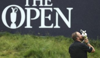 FILE - In this Sunday, July 21, 2019 file photo Ireland&#39;s Shane Lowry holds and kisses the Claret Jug trophy on the 18th green as he poses for the crowd and media after winning the British Open Golf Championships at Royal Portrush in Northern Ireland. The organizers of the British Open announced Monday April 6, 2020, that they have decided to cancel the event in 2020 due to the current Covid-19 pandemic and that the Championship will next be played at Royal St George&#39;s in 2021. (AP Photo/Peter Morrison)