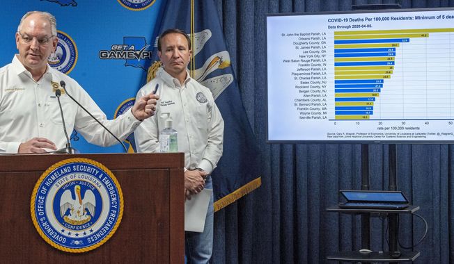 Louisiana Gov. John Bel Edwards talks about a chart as Attorney General Jeff Landry listens, while addressing steps being taken to fight the coronavirus and the status of cases in the state during a press conference at the Governor&#x27;s Office of Homeland Security &amp;amp; Emergency Management, Monday April 6, 2020, in Baton Rouge, La. (Bill Feig/The Advocate via AP, Pool)