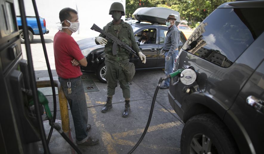 Soldiers loyal to Venezuelan President Nicolas Maduro are guarding gas stations as lines get longer amid a reduction in oil production. (Associated Press)
