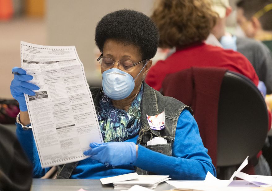 City of Milwaukee Election Commission workers process absentee ballots in Wisconsin's presidential primary election, Tuesday, April 7, 2020, in Milwaukee, Wis. (Mark Hoffman/Milwaukee Journal-Sentinel via AP)