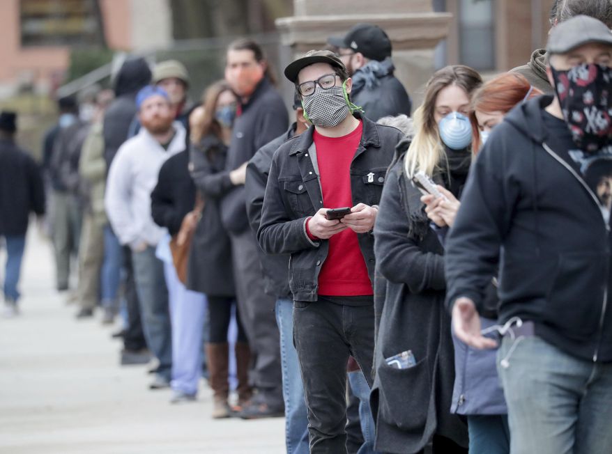 People line up to vote at Riverside High School during the primary in Milwaukee on Tuesday, April 7, 2020. Voters lined up to cast ballots across Wisconsin on Tuesday, ignoring a stay-at-home order in the midst of the coronavirus pandemic to participate in the state&#39;s presidential primary election. (Mike De Sisti/Milwaukee Journal-Sentinel via AP)