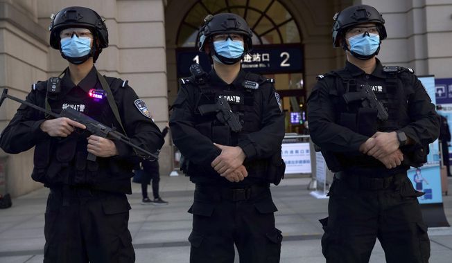 Police officers wearing face masks to protect against the spread of new coronavirus stand guard outside of Hankou train station ahead of the resumption of train services in Wuhan in central China&#x27;s Hubei Province, Wednesday, April 8, 2020. After 11 weeks of lockdown, the first train departed Wednesday morning from a re-opened Wuhan, the origin point for the coronavirus pandemic, as residents once again were allowed to travel in and out of the sprawling central Chinese city. (AP Photo/Ng Han Guan)