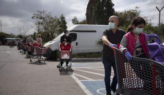 Customers wear face masks as they line up to enter a supermarket keeping social distancing following the government&#39;s measures to help stop the spread of the coronavirus, in Tel Aviv, Israel, Tuesday, April 7, 2020. Israeli Prime Minister Benjamin Netanyahu announced Monday a complete lockdown over the upcoming Passover holiday to control the country&#39;s coronavirus outbreak, but offered citizens some hope by saying he expects to lift widespread restrictions after the week-long festival. (AP Photo/Oded Balilty)