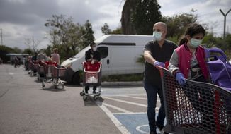 Customers wear face masks as they line up to enter a supermarket keeping social distancing following the government&#39;s measures to help stop the spread of the coronavirus, in Tel Aviv, Israel, Tuesday, April 7, 2020. Israeli Prime Minister Benjamin Netanyahu announced Monday a complete lockdown over the upcoming Passover holiday to control the country&#39;s coronavirus outbreak, but offered citizens some hope by saying he expects to lift widespread restrictions after the week-long festival. (AP Photo/Oded Balilty)