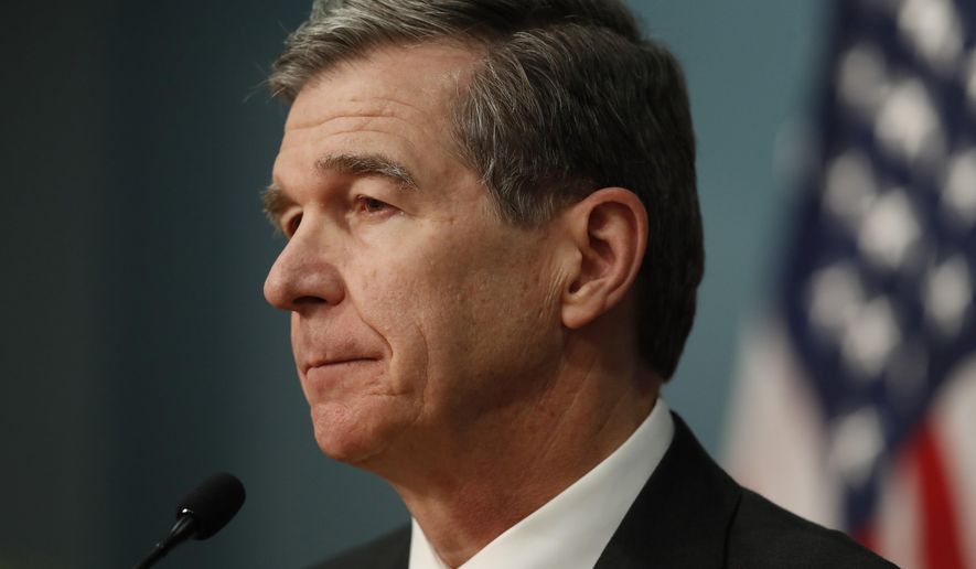 North Carolina Gov. Roy Cooper gives an update on the state's response to COVID-19 and the coronavirus at the State of North Carolina's Emergency Operations Center in Raleigh, N.C., Tuesday, March 31, 2020. (Ethan Hyman/The News & Observer via AP)