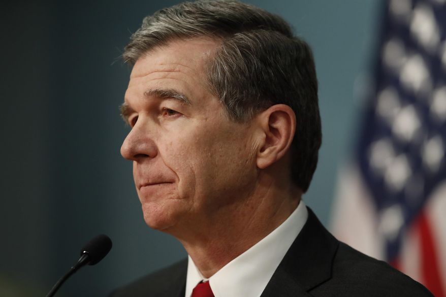 North Carolina Gov. Roy Cooper gives an update on the state's response to COVID-19 and the coronavirus at the State of North Carolina's Emergency Operations Center in Raleigh, N.C., Tuesday, March 31, 2020. (Ethan Hyman/The News & Observer via AP)
