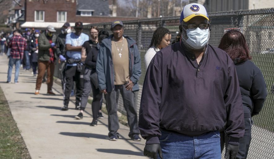 Voters observe social distancing guidelines as they wait in line to cast ballots at Washington High School while ignoring a stay-at-home order over the coronavirus threat to vote in the state's presidential primary election, Tuesday, April 7, 2020, in Milwaukee. (AP Photo/Morry Gash)