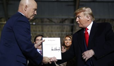 President Donald Trump shakes hands with Gen. Jay Raymond, after signing the letter of his appointment as the chief of space operations for U.S. Space Command during a signing ceremony for the National Defense Authorization Act for Fiscal Year 2020 at Andrews Air Force Base, Md., Friday, Dec. 20, 2019. (AP Photo/Andrew Harnik)  **FILE**


