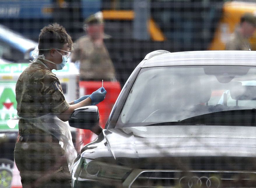 Military Personnel carry out virus testing at a testing facility in the long stay car park at Glasgow Airport as the U.K. continues its lockdown to help curb the spread of the coronavirus, in Glasgow, Scotland, Wednesday, April 8, 2020. The highly contagious COVID-19 coronavirus has impacted on nations around the globe, many imposing self-isolation and exercising social distancing when people move from their homes. (Andrew Milligan/PA via AP)
