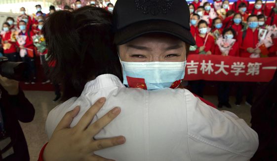 A medical worker from China&#39;s Jilin Province reacts as she prepares to return home at Wuhan Tianhe International Airport in Wuhan in central China&#39;s Hubei Province, Wednesday, April 8, 2020. Within hours of China lifting an 11-week lockdown on the central city of Wuhan early Wednesday, tens of thousands people had left the city by train and plane alone, according to local media reports. (AP Photo/Ng Han Guan)