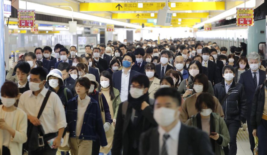 Commuters wear masks at a station in Fukuoka, southern Japan Wednesday morning, April 8, 2020. Japan’s Prime Minister Shinzo Abe declared a month-long state of emergency Tuesday for Tokyo and six other prefectures including Fukuoka to ramp up defenses against the spread of the coronavirus as the number of infections surges. (Kyodo News via AP)