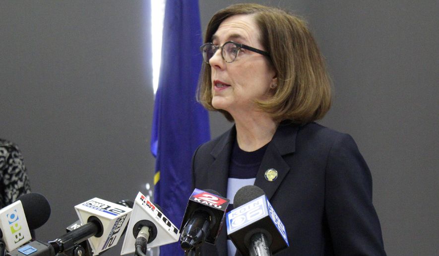 FILE - In this March 16, 2020, file photo, Gov. Kate Brown speaks at a news conference to announce a four-week ban on eat-in dining at bars and restaurants throughout the state in Portland, Ore., to slow the spread of the new coronavirus. Brown said Wednesday, April 8, 2020, that Oregon's K-12 schools will remain closed though the end of the academic year due to the coronavirus outbreak, placing the state's more than 550,000 students and their teachers in uncharted territory as districts with vastly different resources plan for weeks of remote learning. (AP Photo/Gillian Flaccus, File)