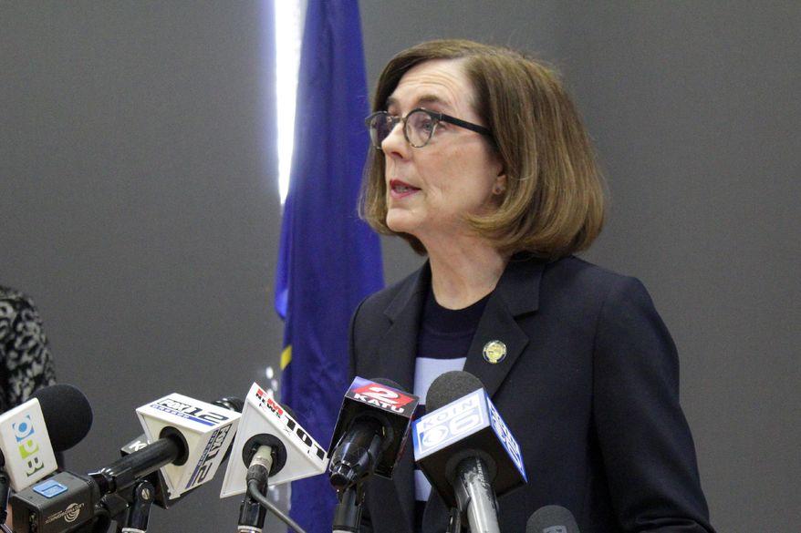 FILE - In this March 16, 2020, file photo, Gov. Kate Brown speaks at a news conference to announce a four-week ban on eat-in dining at bars and restaurants throughout the state in Portland, Ore., to slow the spread of the new coronavirus. Brown said Wednesday, April 8, 2020, that Oregon's K-12 schools will remain closed though the end of the academic year due to the coronavirus outbreak, placing the state's more than 550,000 students and their teachers in uncharted territory as districts with vastly different resources plan for weeks of remote learning. (AP Photo/Gillian Flaccus, File)