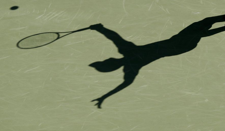 FILE - This is a 2017 file photo showing the shadow of a tennis player. The group charged with monitoring tennis gambling and punishing corruption found a near-doubling in the number of suspect matches in the first three months of 2020 -- an increase it tied to the coronavirus pandemic. (AP Photo/File)