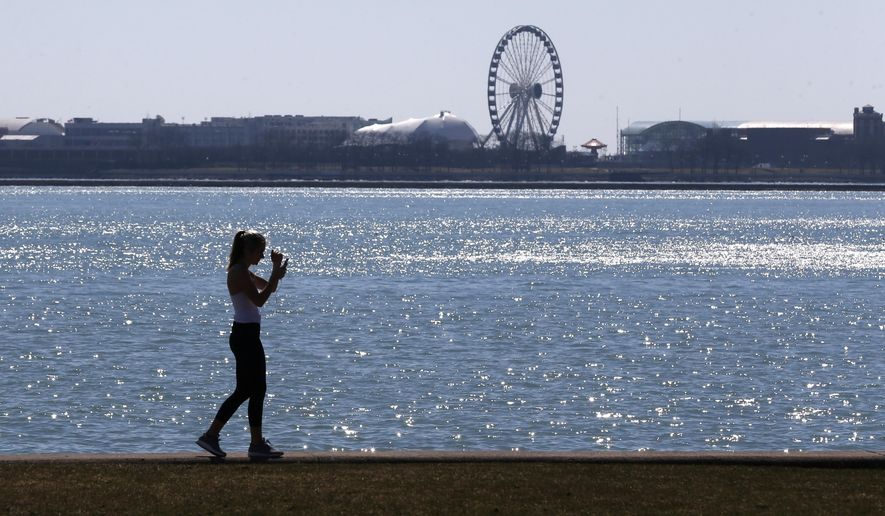 FILE - In this March 24, 2017 file photo, a lone woman walks the trail along Lake Michigan at Chicago&#39; North Avenue beach. Additional funds provided by Congress for Great Lakes environmental improvements will be used to quicken cleanups of highly toxic sites and step up work on other longstanding forms of pollution, federal officials said Thursday, April, 9, 2020. (AP Photo/Charles Rex Arbogast, File)