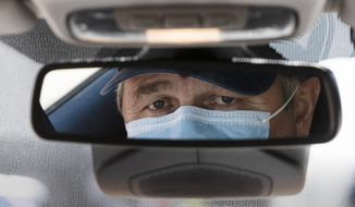 Taxi driver Nicolae Hent, wearing a protective mask, poses for a photograph before before starting work in New York, Monday, April 6, 2020. A taxi driver&#39;s job was already tougher in recent years with the arrival of ride-sharing companies such as Uber and Lyft. The empty streets during the coronavirus pandemic have made things more difficult. (AP Photo/Matt Rourke)