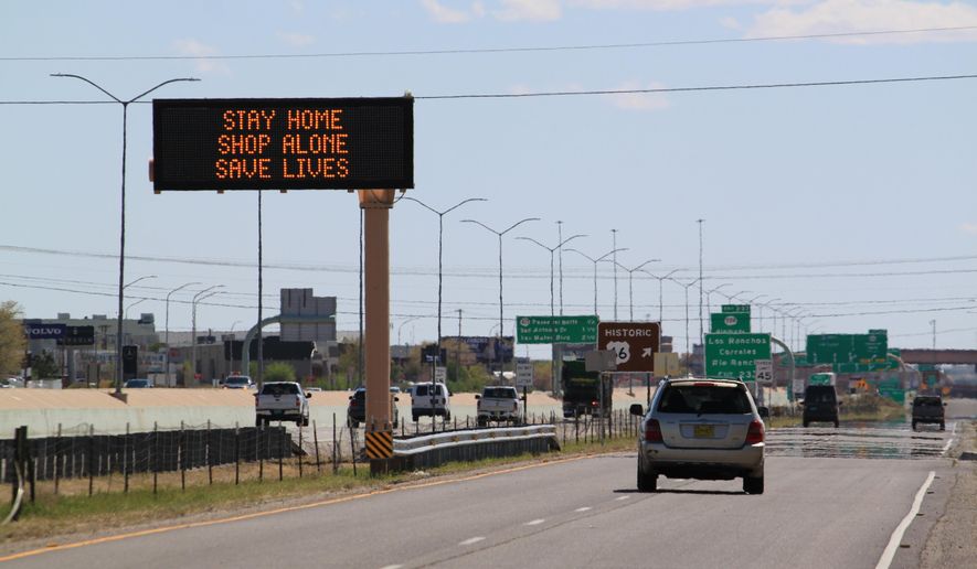 Flashing highway message boards along Interstate 25 in Albuquerque, New Mexico, urge people in both English and Spanish to stay home amid the coronavirus outbreak on Thursday, April 9, 2020. The new coronavirus causes mild or moderate symptoms for most people, but for some, especially older adults and people with existing health problems, it can cause more severe illness or death.(AP Photo/Susan Montoya Bryan)