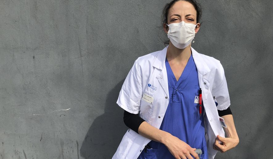 In this photo taken on Tuesday, April 7, 2020, Aurelie Gouel, an ICU doctor, poses during a break in her shift treating COVID-19 patients at Bichat Hospital in Paris. Gouel was infected by the new coronavirus in March but rushed back to work as soon as she recovered from her high fever, cough and other symptoms because she felt compelled to rejoin the fight to save lives. The coronavirus has infected so many doctors, nurses and other health workers that some are now returning to work hoping that they are now armed with some degree of immunity. (AP Photo/John Leicester)